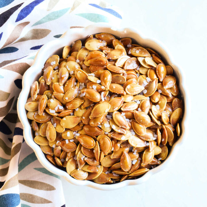 Salt and Vinegar Pumpkin Seeds served in a white bowl with a napkin.