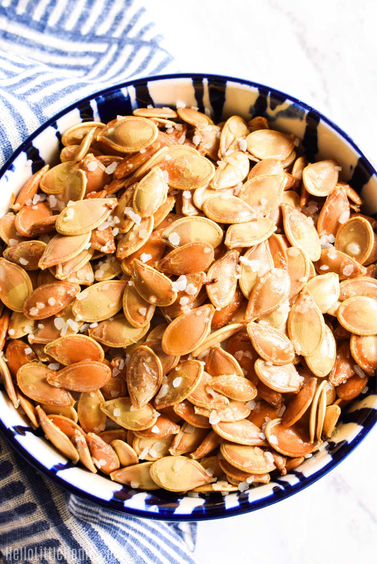 Homemade Salted Pumpkin Seeds served with a striped napkin.