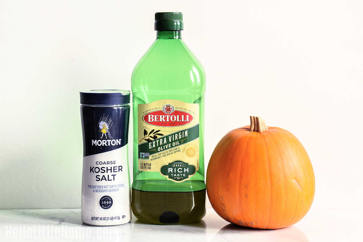 Ingredients for making Salty Pumpkin Seeds gathered together on a marble counter.