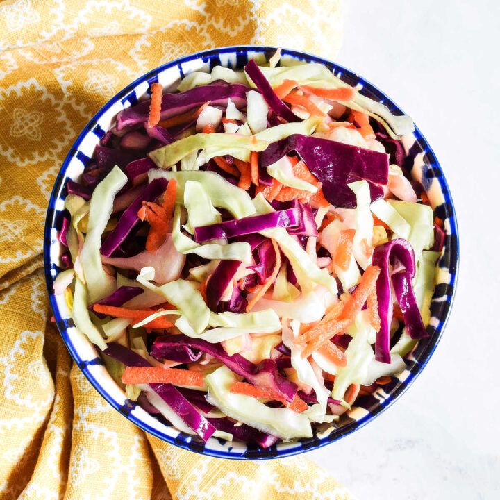 Homemade Taco Slaw served in a bowl next to a yellow napkin.